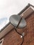 Stock Photo - a black sky dish satelite up close on brick wall
