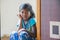 Stock photo of dark brown color girl 5 to 10 year old Indian girl sitting near door wearing blue color night dress looking at