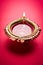 Stock photo of diwali diya or clay lamp over red background, happy diwali