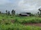 Stock photo of group of man made steel sheet shelters cover with black plastic sheet under dizzy or cloudy sky