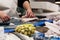 Stock photo of the hands of a fishmonger cutting a piece of fish