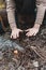 A stock photo of a man in nature sitting by a small fire, warming himself