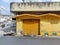 Stock photo of old yellow painted commercial shop with yellow painted shutter of the shop