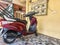 Stock photo of red color Honda Aviator scooter or bike parked inside of parking area of residential building.