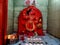 Stock photo of saffron color painted lord Hanuman idol in the temple, devotees offer flowers