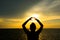 Stock Photo - Silhouetted woman forming a heart symbol at golden