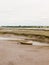 Stock Photo - single old boat in mud sea coast no people browns