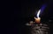 Stock photo of a white color small candle with calm yellow and blue color flame with dark black background. Matchsticks and melted