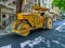 Stock photo of a yellow color road roller parked on the newly constructed damber road for rolling black topping for renovation of