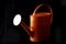 Stock photograph of an orange watering can