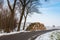 Stock pile sawed trees along the side of the road in winter