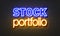 Stock portfolio neon sign on brick wall background.