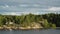 Stockholm Archipelago. Swedish archipelago nature on sunny day in summer. Green forest trees at shoreline. Sweden nature