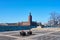Stockholm city hall in daylight against a blue sky with waves on water.