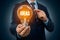 StockImage Businessman holds light bulb, indicating new ideas, 3D illustration