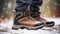 stockphoto, Hiker\\\'s Boots in the snow. used hiking boots standing on the soil in a snowy landscape. Hiking boots