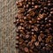 StockPhoto Roasted coffee beans create a warm backdrop on traditional textile