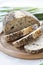 Stollen traditional German Christmas yeast cake with raisins served with a cup of coffee decorated with tablecloth on wooden table