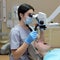 Stomatologist examining teeth of patient with help of professional dental microscope. Dentist preventing caries using restoration