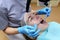 Stomatologist examining teeth of patient with help of professional dental microscope. Dentist preventing caries using restoration