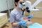 Stomatologist examining teeth of patient with help of professional dental microscope. Dentist preventing caries using restoration