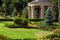 Stone arbor with columns in the park with landscape design.