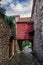 Stone arch cobblestone pavement interconnecting houses on alley without crowd.