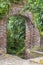 Stone arch with leaves. The ancient stone arch was overgrown with greenery. concept of human life with nature. Background of a