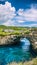 Stone arch over the sea. Broken beach. Rock coastline. Nusa Penida, Indonesia.