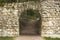 Stone arch, semi-circular roof of the passageway in an old stone wall, manhole entrance aperture the grotto