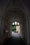 Stone arched corridor constructed from white stones and the doorway in the end of tunnel with Shadows and Light. dark hallway with