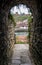 Stone arched passageway through historic wall with view on other side including Whitby Abby
