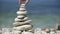 Stone balance closeup. Female hand making pebbles tower from sea stones. Stack of stones on seashore.