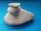 Stone balance with three different sized stones over blue background. Pebbles stack.