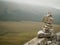 Stone balance tower against mountains blurred background. Selective focus, copy space. Concept hikers have fun, patience and