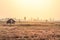 A stone barn stands in misty grasslands at dawn.