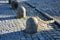 Stone barriers in a square shaped cylinder with a hemisphere on top. granite curbs as stops at the parking lot. chain decorative f