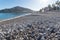 Stone beach of Albir with view on the promenade and mountain, Costa Blanca, Spain