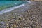 Stone beach low angle view, pebbles  turquoise sea wate and snorkeler swimming