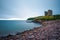 Stone beach and the Minard Castle situated on the Dingle Peninsula in Ireland