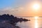 Stone beach on the sea shore. blue sky horizon. reflection of the sunrise