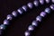 Stone beads necklace purple color on a dark background