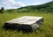 Stone bench on the meadow with mountains in the background - shallow depth of field