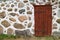 Stone boulder wall with red wooden door