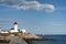 Stone Breakwater by Harbor Lighthouse in Mssachusetts with Sailboat in Distance