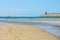 Stone breakwater, sandy beach, blue sea.