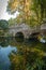 Stone bridge with arches and reflection in the water in the Nymph Gardens in the province of Latina in Italy