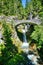 Stone bridge crosses steps of Christine falls