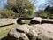 Stone bridge over a creek in the Asian garden with stones in the front