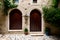 A stone building with two wooden doors and a potted plant.